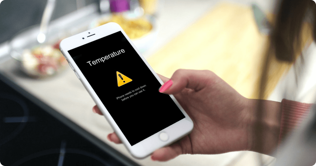 iphone with overheating message warning in the hands of a woman