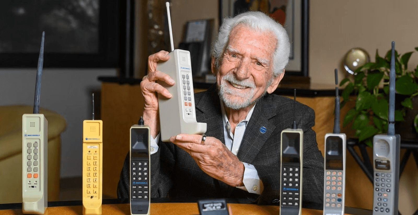 an elderly man holding a portable mobile phone