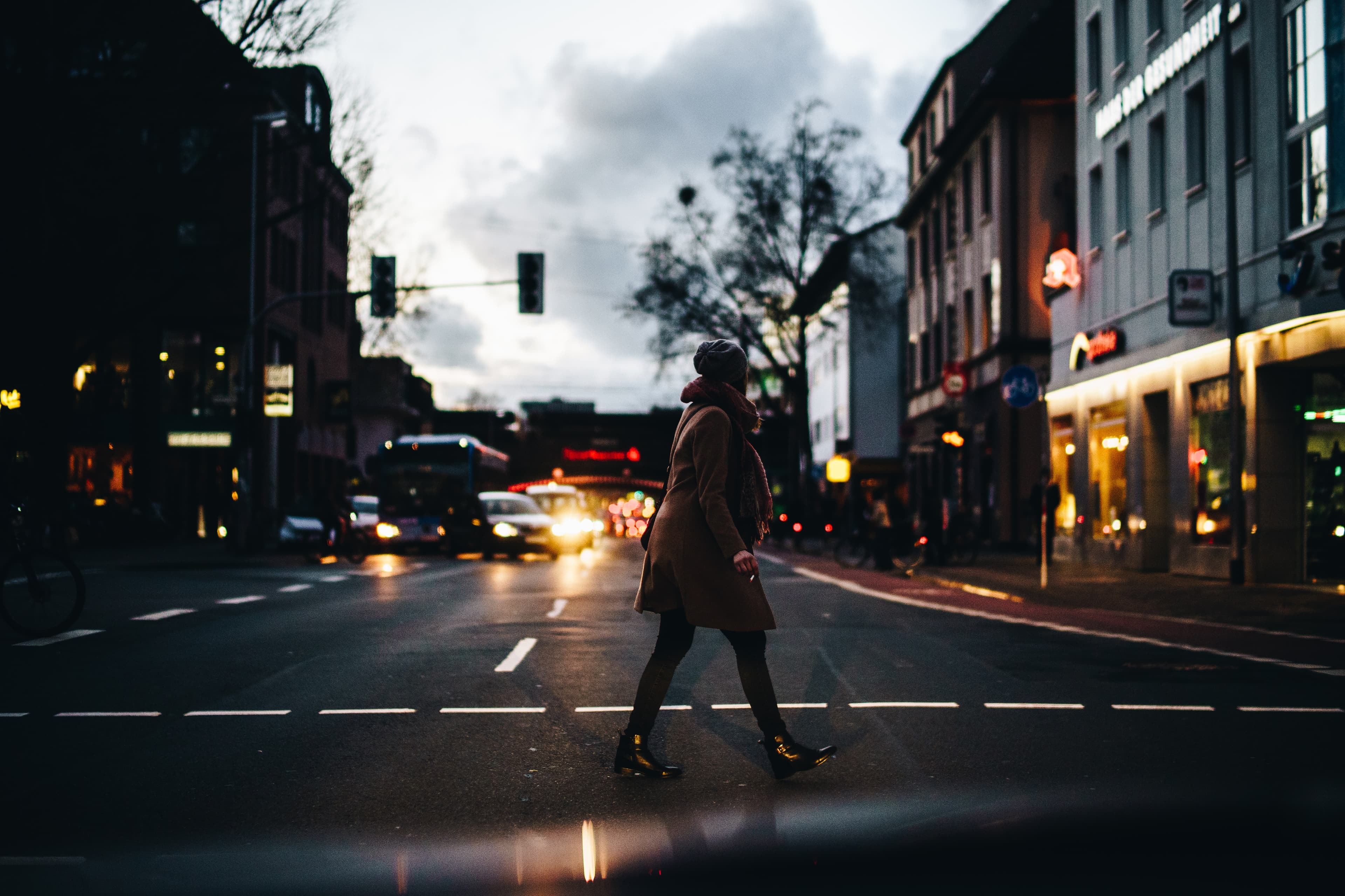 Woman walking on street with cars