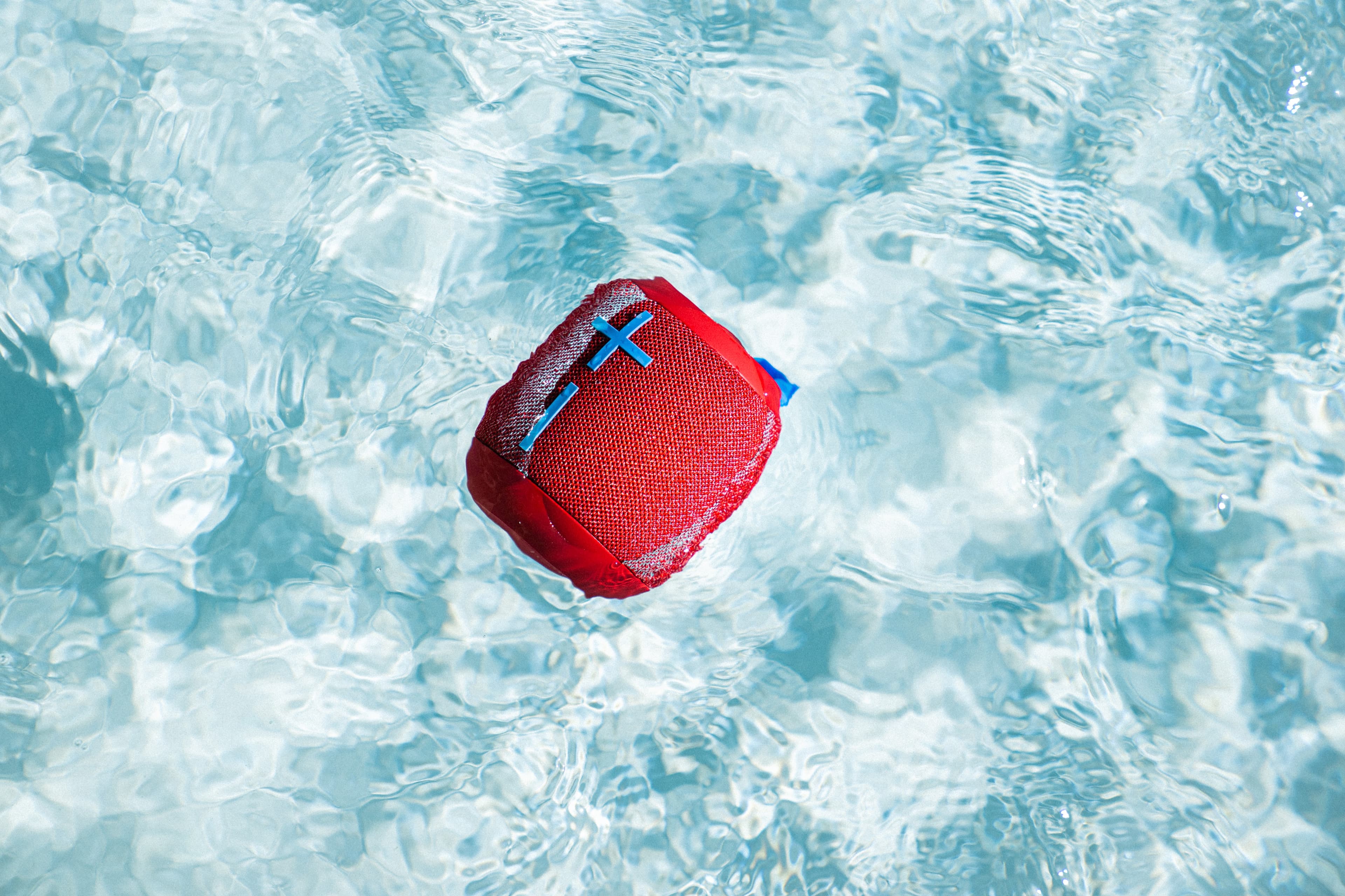 Red bluetooth speaker in pool