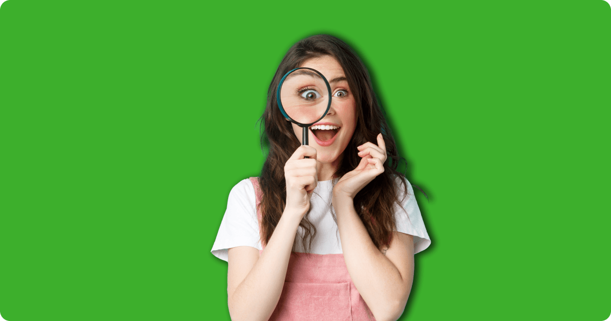 Woman excitedly looking through a magnifying glass