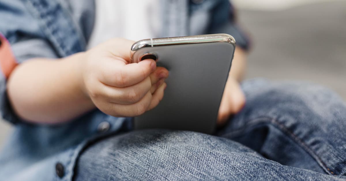 Closeup of a mobile phone held by a child's hand