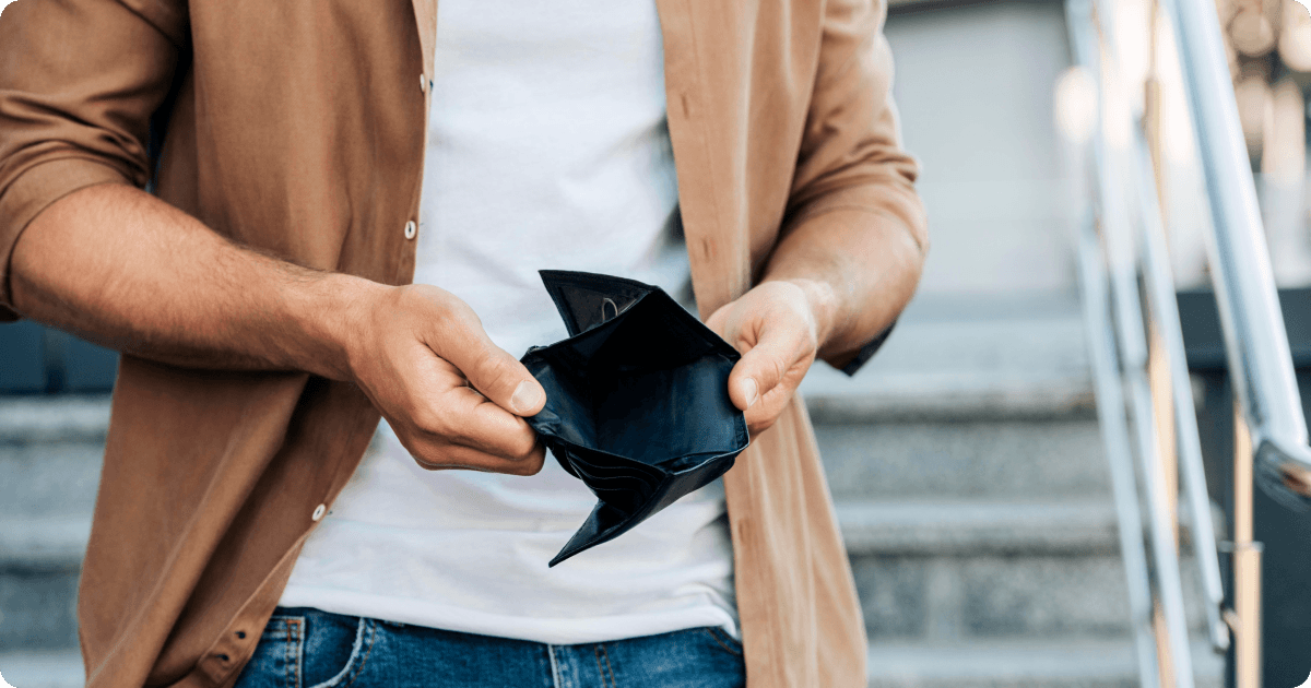 Man holding empty wallet showing he has no money