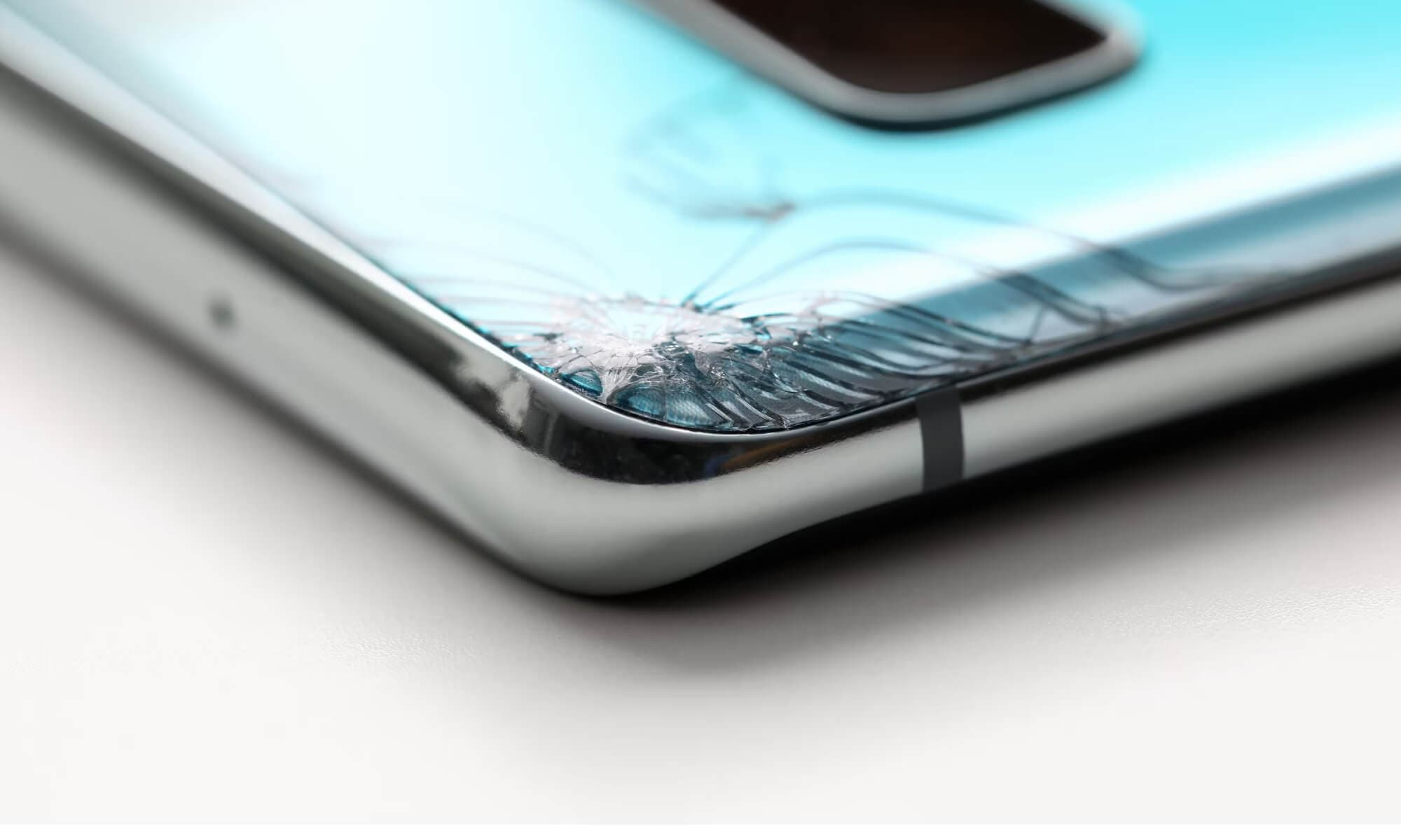 modern smartphone lying on table cracked corner