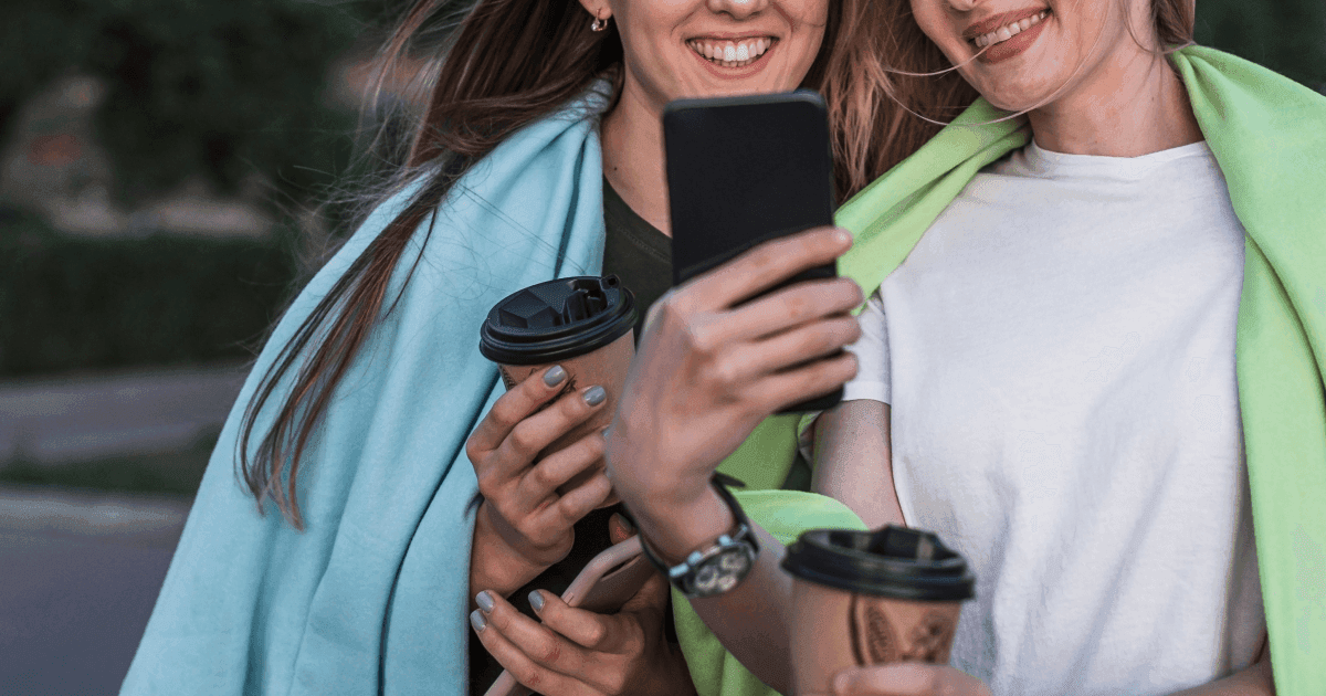 Two women smiling looking at phone