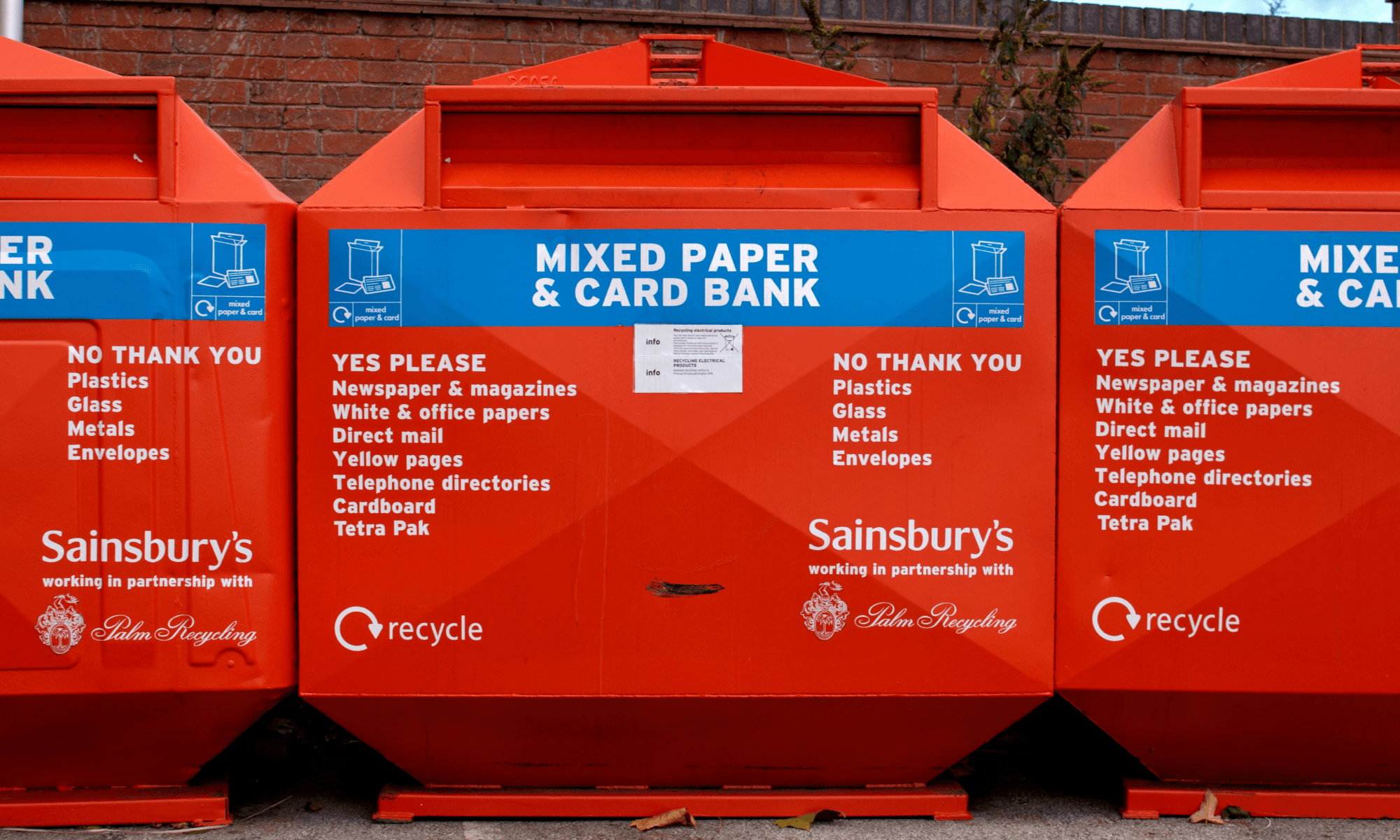 orange industrial bins with recycle symbol and sainbury's logo
